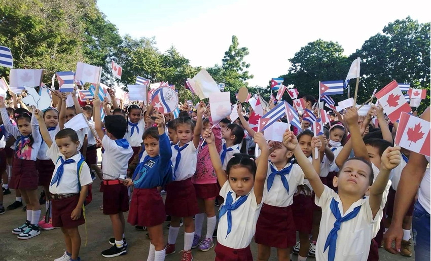 escolares holguineros, banderas de Cuba y Canadá
