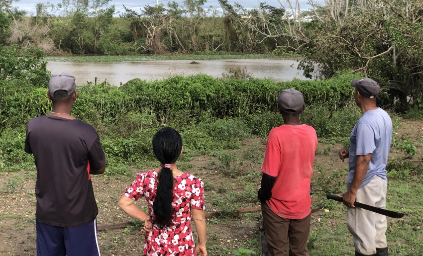 Fermín junto a su familia observando los daños de Melissa